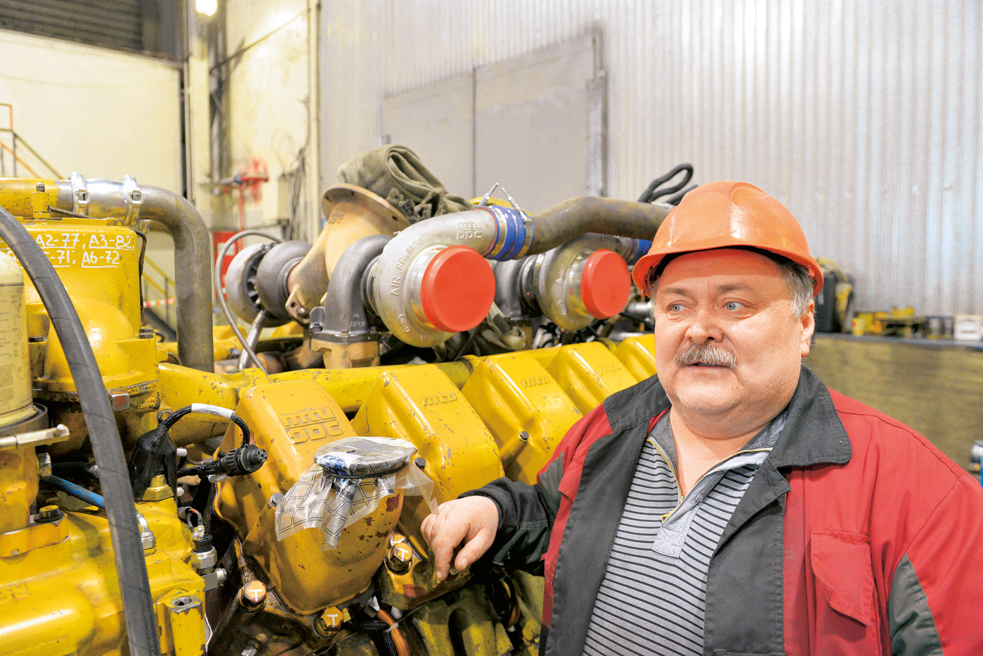  Wenjamin Metelski arbeitet seit 2005 als Mechaniker an den MTU-Motoren. Stolz erzählt er, dass der MTU-Motor an dem er lehnt schon weit mehr als 60.000 Betriebsstunden gelaufen ist.